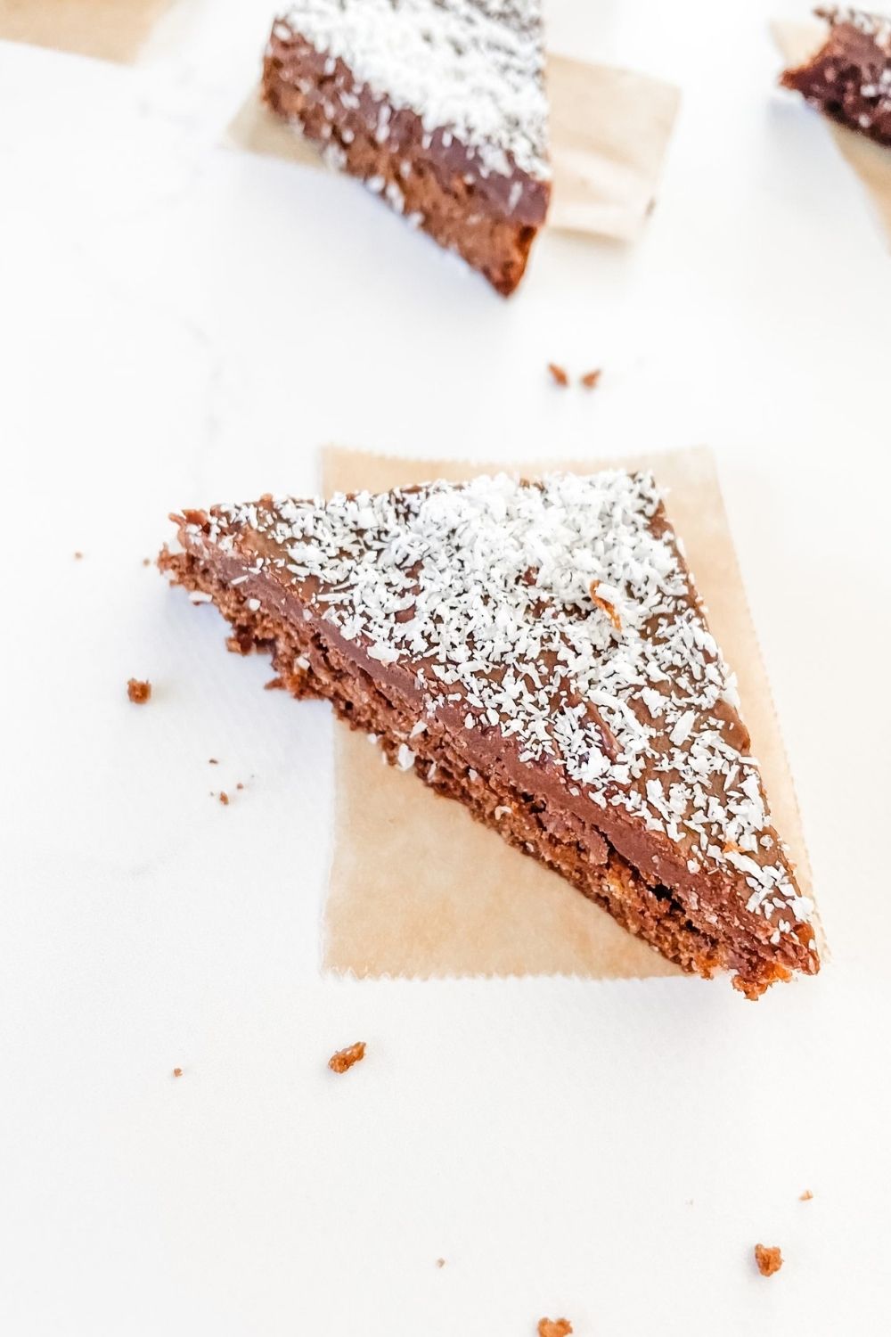 Simple chocolate slice recipe topped with chocolate icing and coconut - a lamington slice