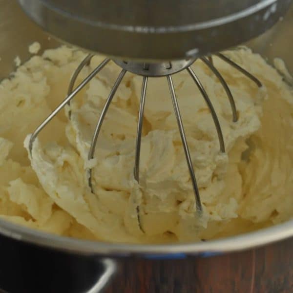 Cream and vanilla in a stand mixer being whipped