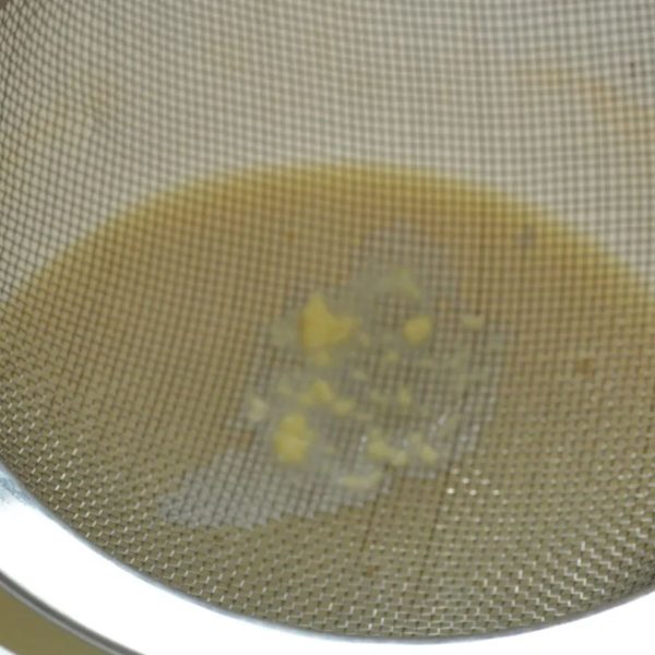 Homemade vanilla butter straining the buttermilk