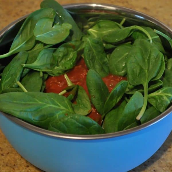 Adding baby spinach and meat sauce to cottage cheese