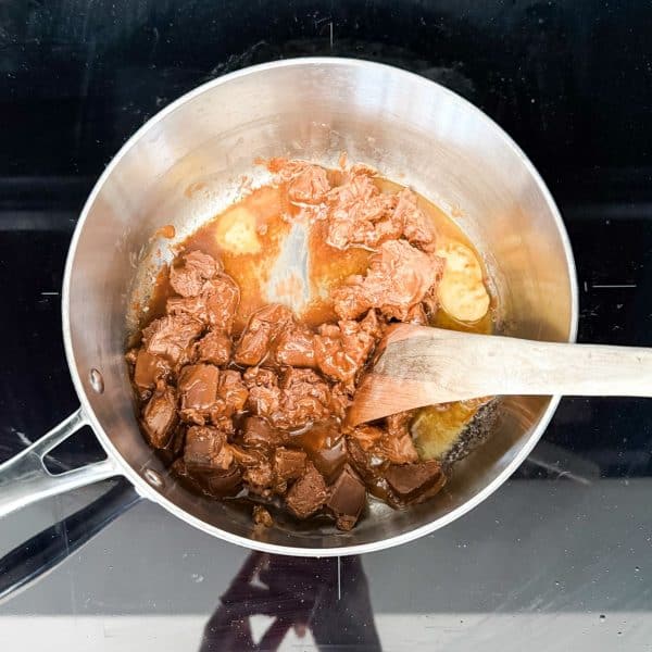 Melting butter and mars bars to make mars bar slice