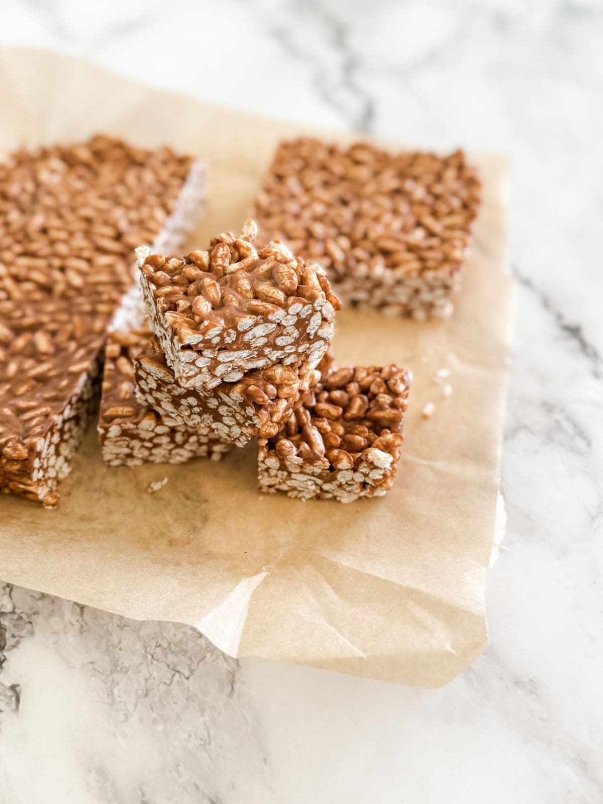 Pile of squares of mars bar slice on baking paper