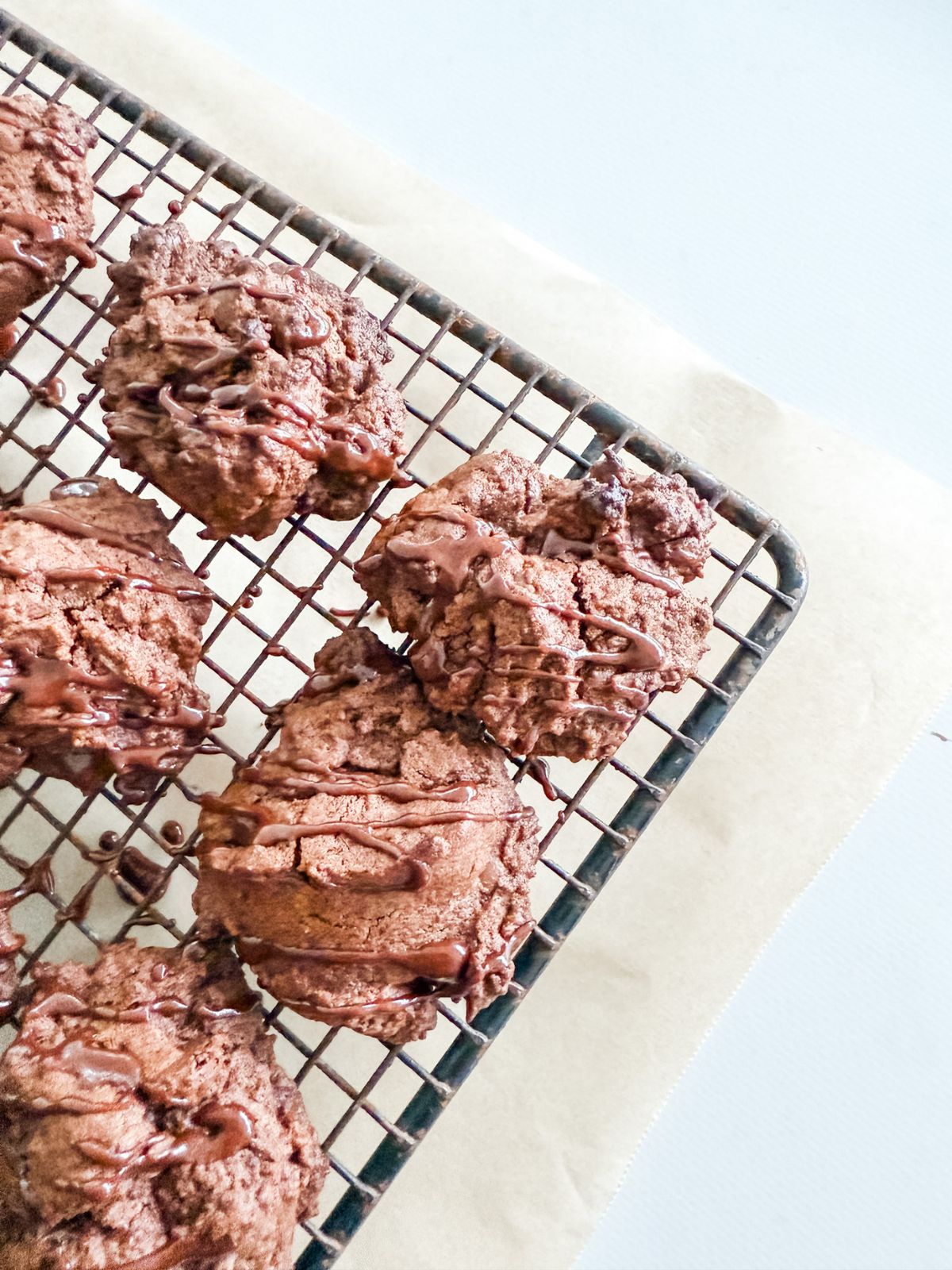 Choc mint biscuits - Chocolate chip cookies drizzled with chocolate peppermint icing on a wire rack. 