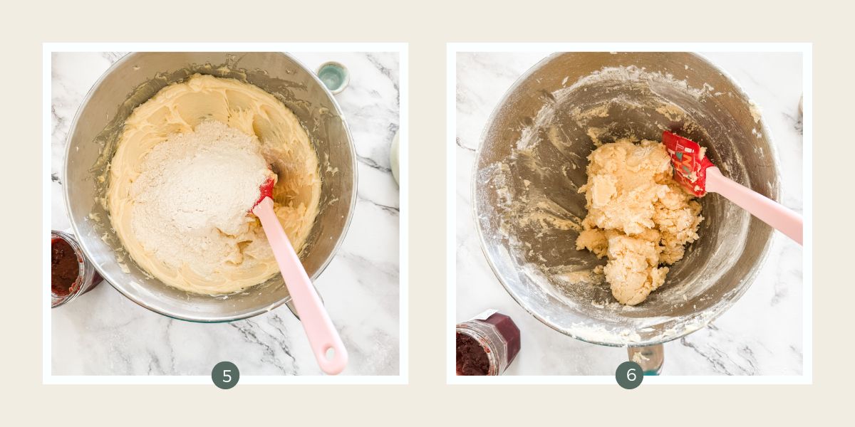 Folding flour into jam drop biscuit dough batter using a red spatular in a silver bowl. 