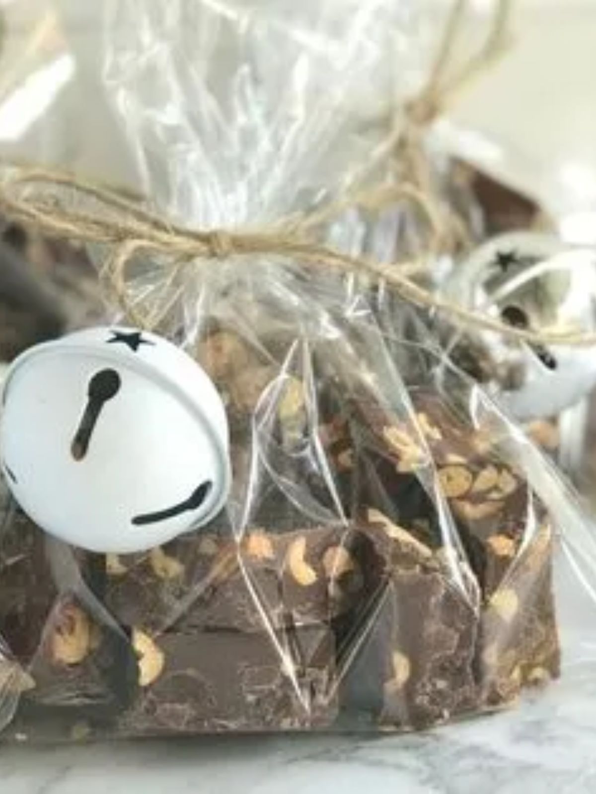 Chocolate chunks with peanuts and caramel in cello bags with white bell attached.