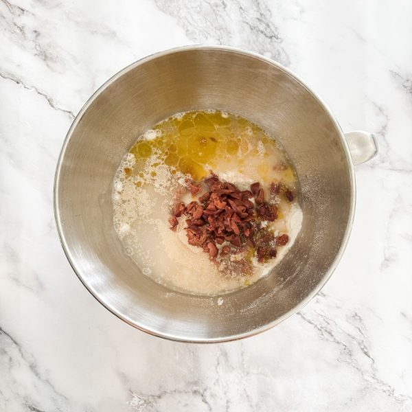 Ingredients for making olive bread in the bowl of an electric mixer. 