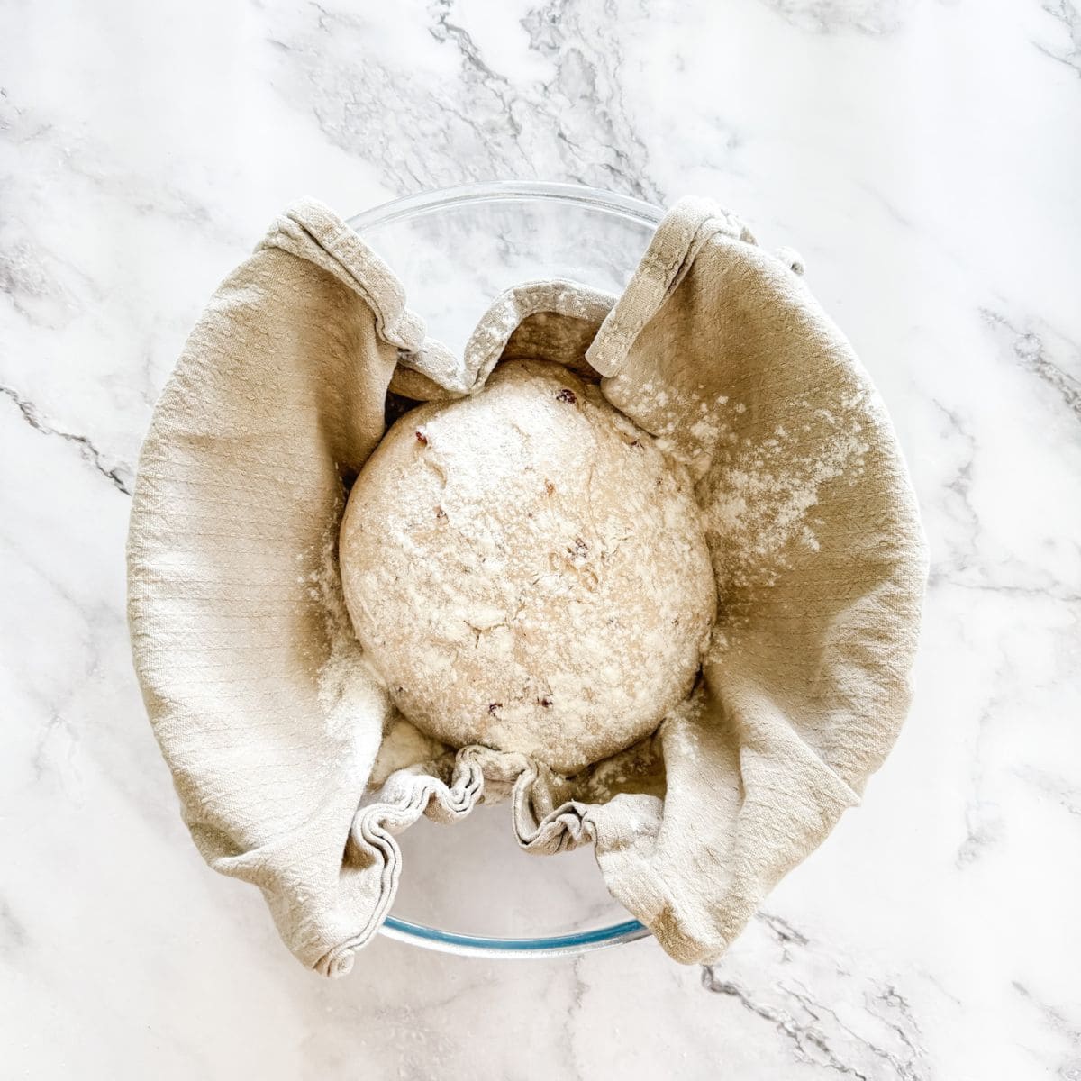 Olive dough in floured tea towel in a bowl