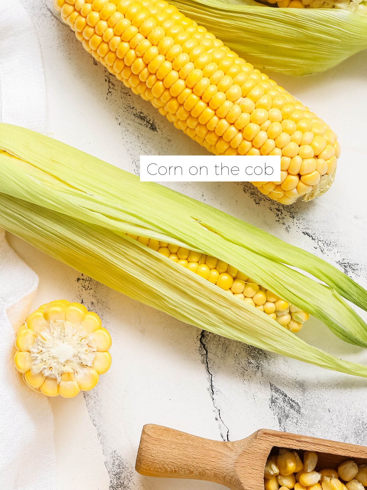 Corn on the cob on a white marble bench top.