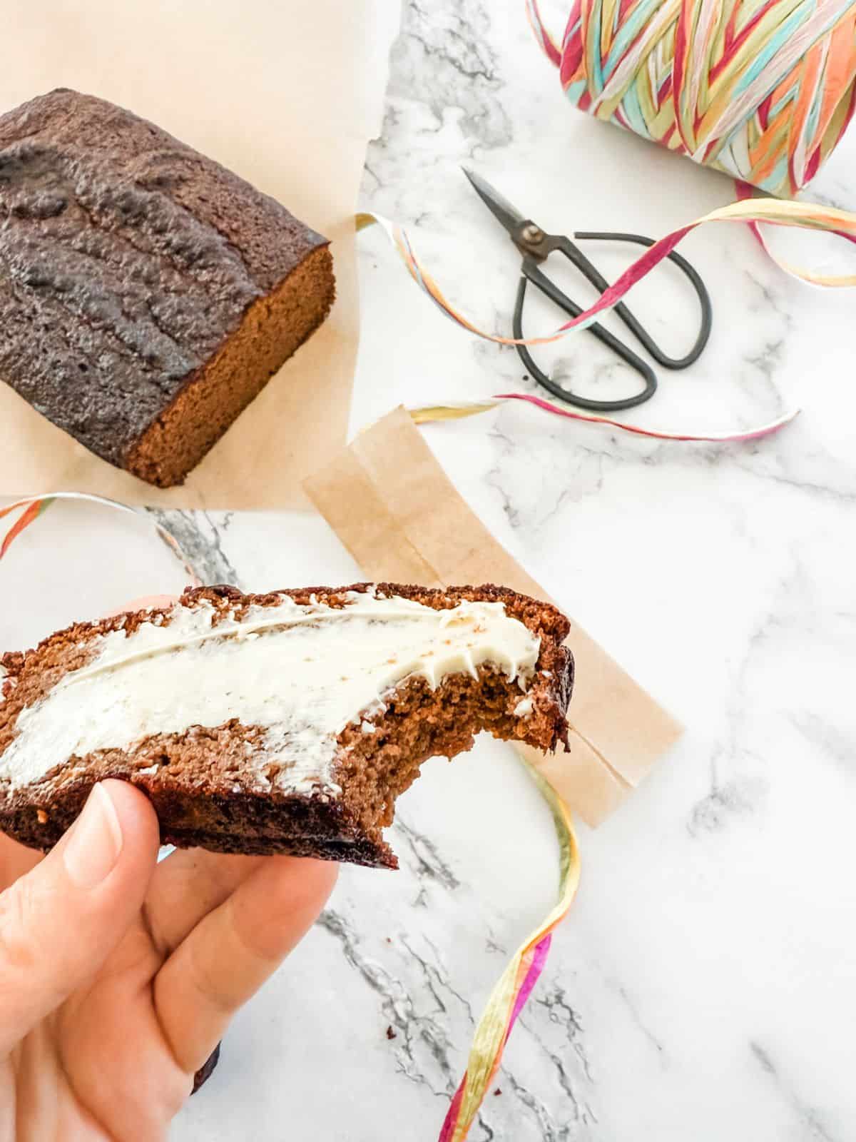 Gluten-Free Gingerbread Loaf Cake with butter and a bite taken out of it. 