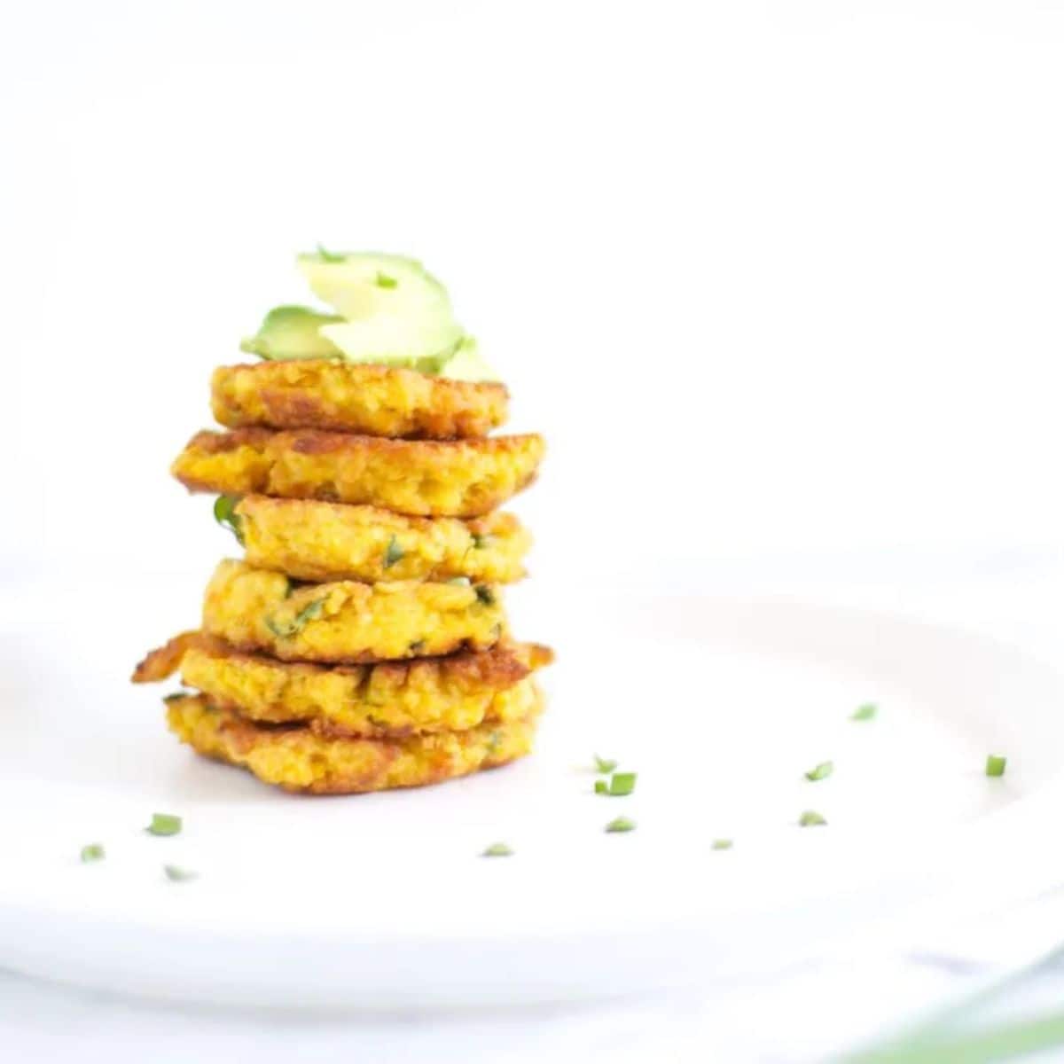 Pumkin spinach and feta fritters topped with avocado