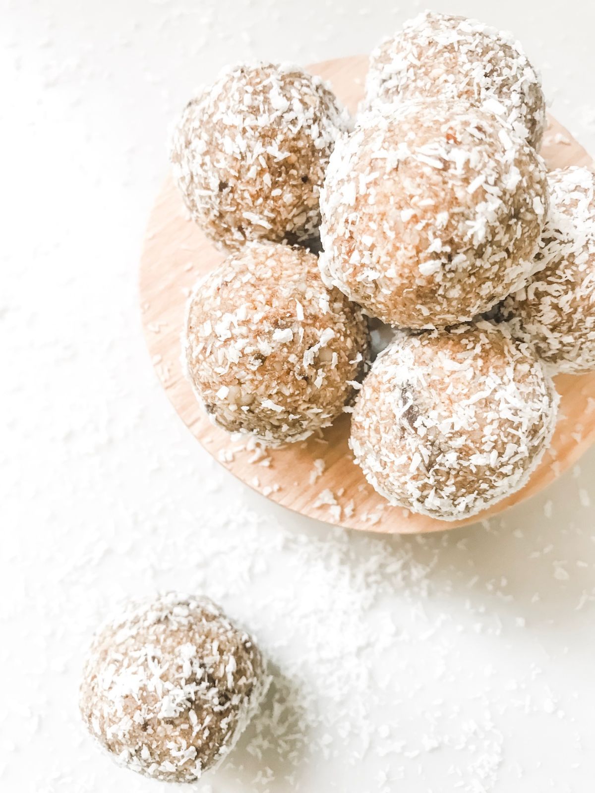 Banana bread bliss balls on a plate on a white marble bench.