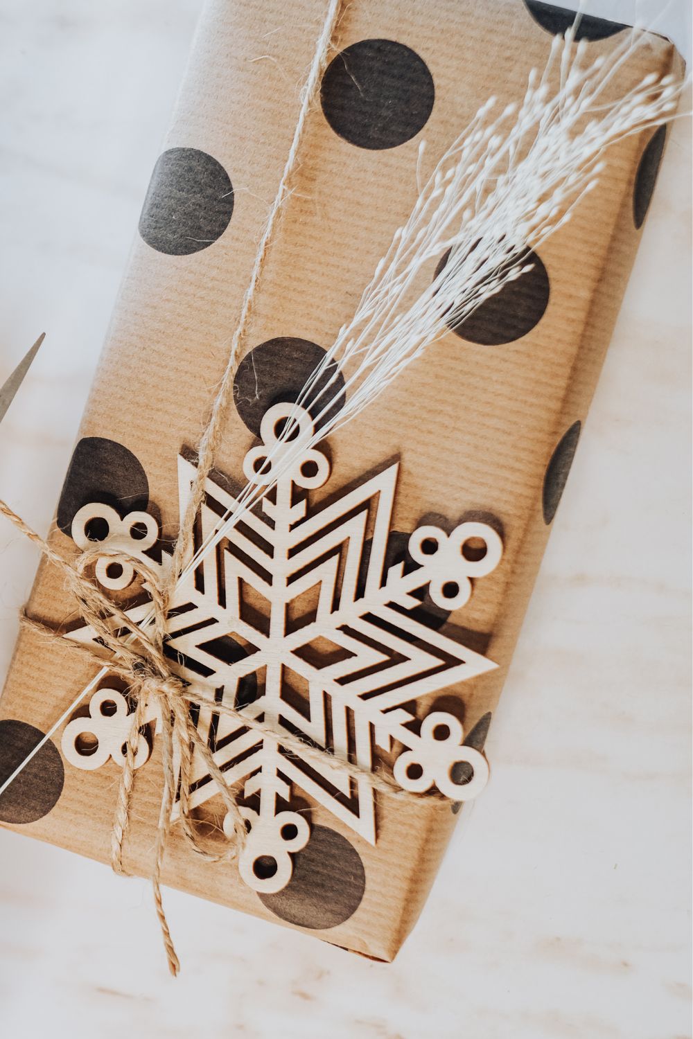 Christmas present wrapped with brown paper and finished with an ornament