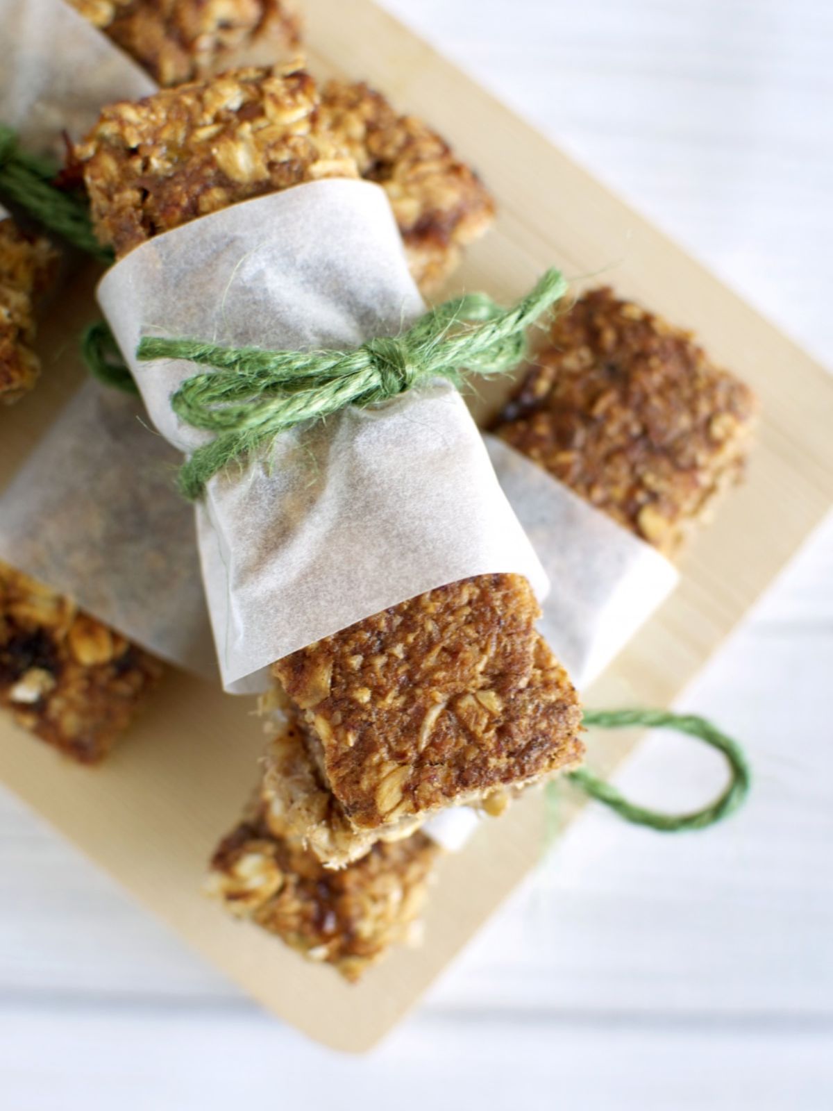 Homemade banana muesli bar wrapped in a band of baking paper tied with green twine. 