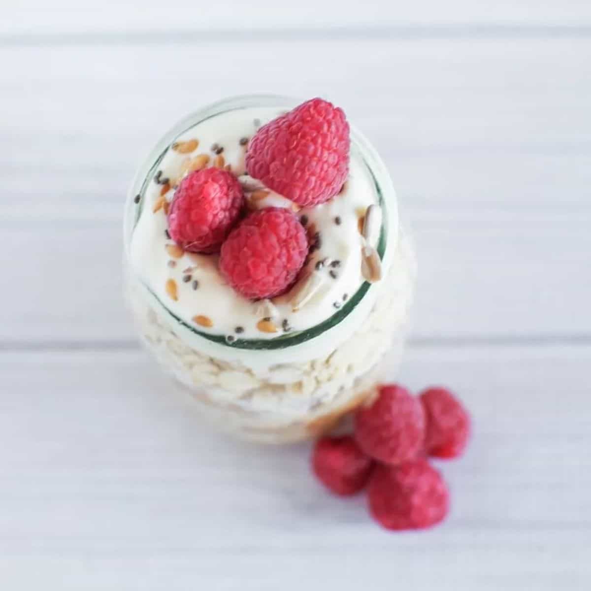 Bircher muesli in individual glass jar topped with fresh raspberries