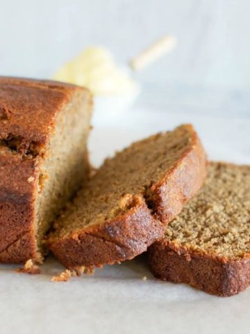 Kid friendly banana bread - with two slices off the end. A little ceramic ramekin of butter in the background