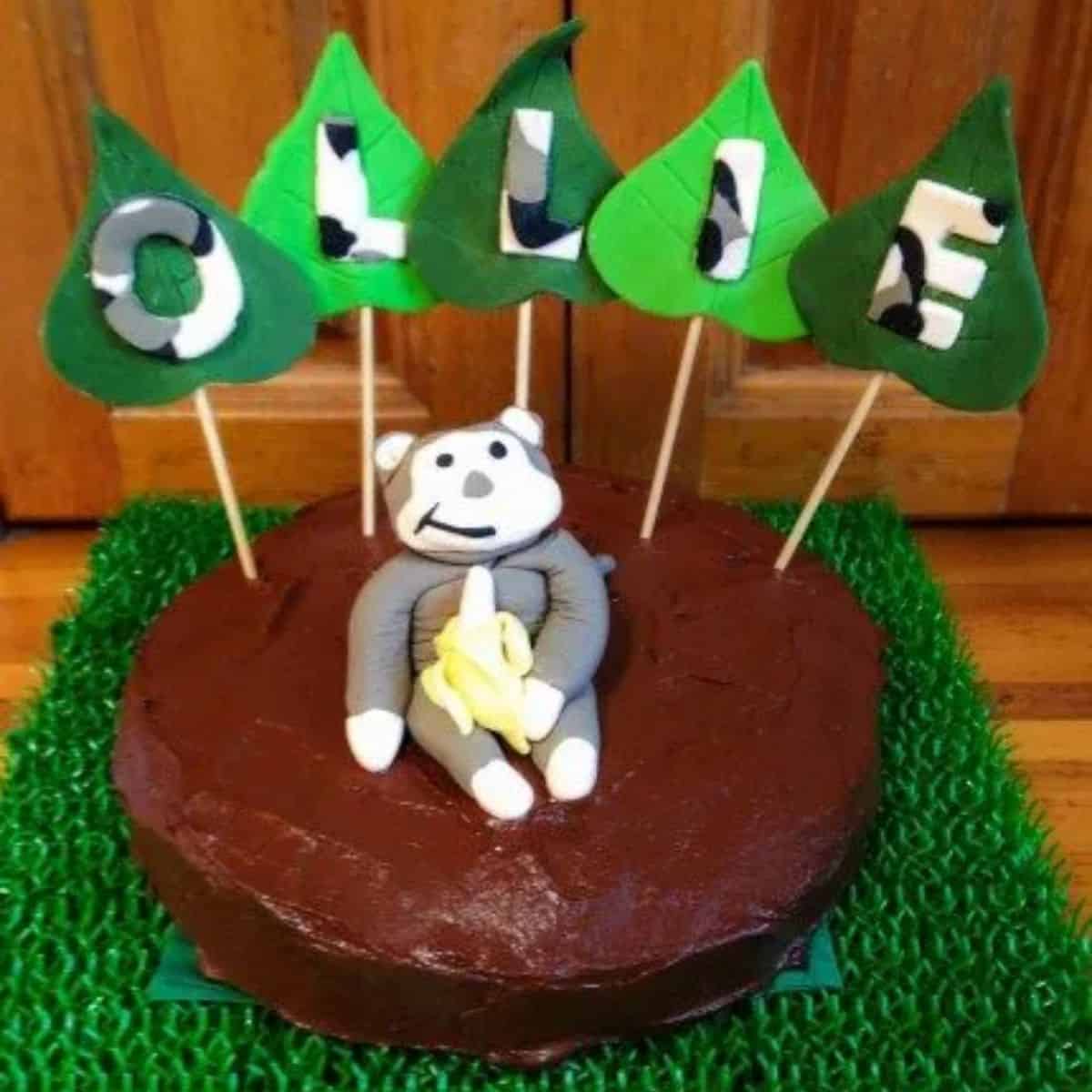 Kid friendly banana cake with chocolate icing - chocolate cake with monkey cake topper and jungle leaves