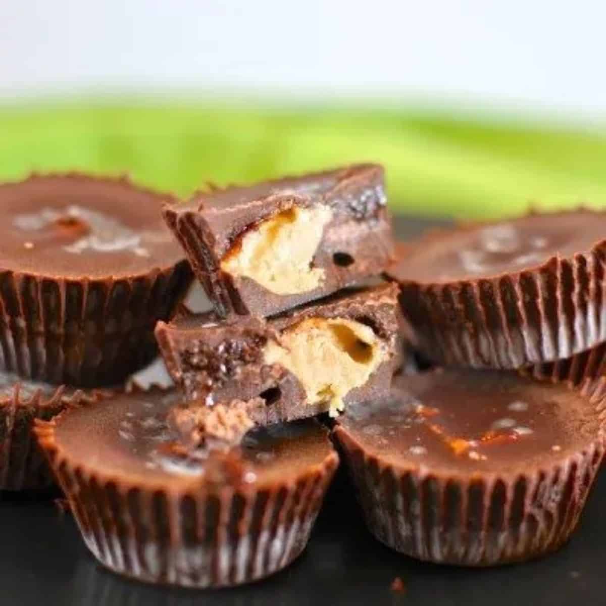 Raw peanut butter chocolate cups - 5 chocolate cups one cut in half to show peanut butter filling.