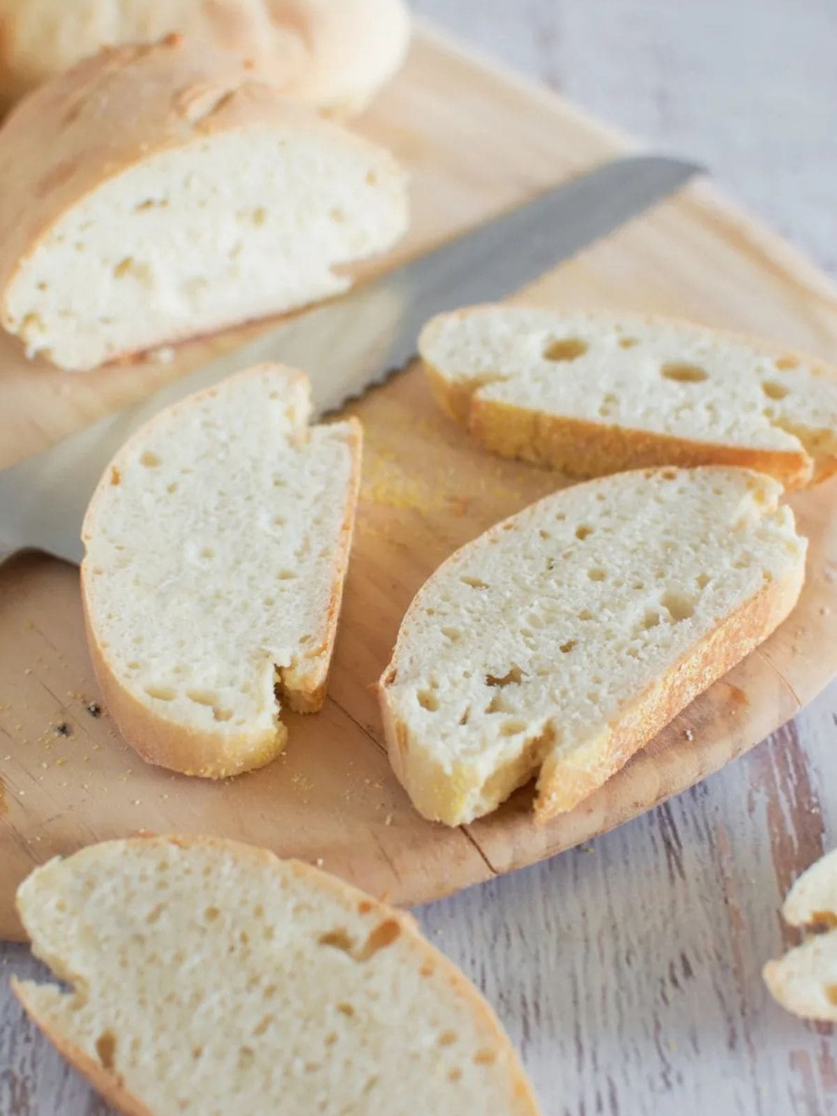 30 minute bread sliced on a chopping board with a silver bread knife