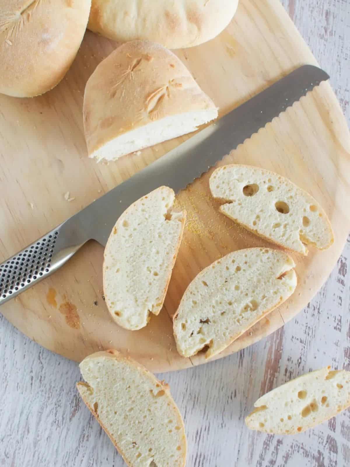 30 minute bread sliced on a chopping board with a silver bread knife