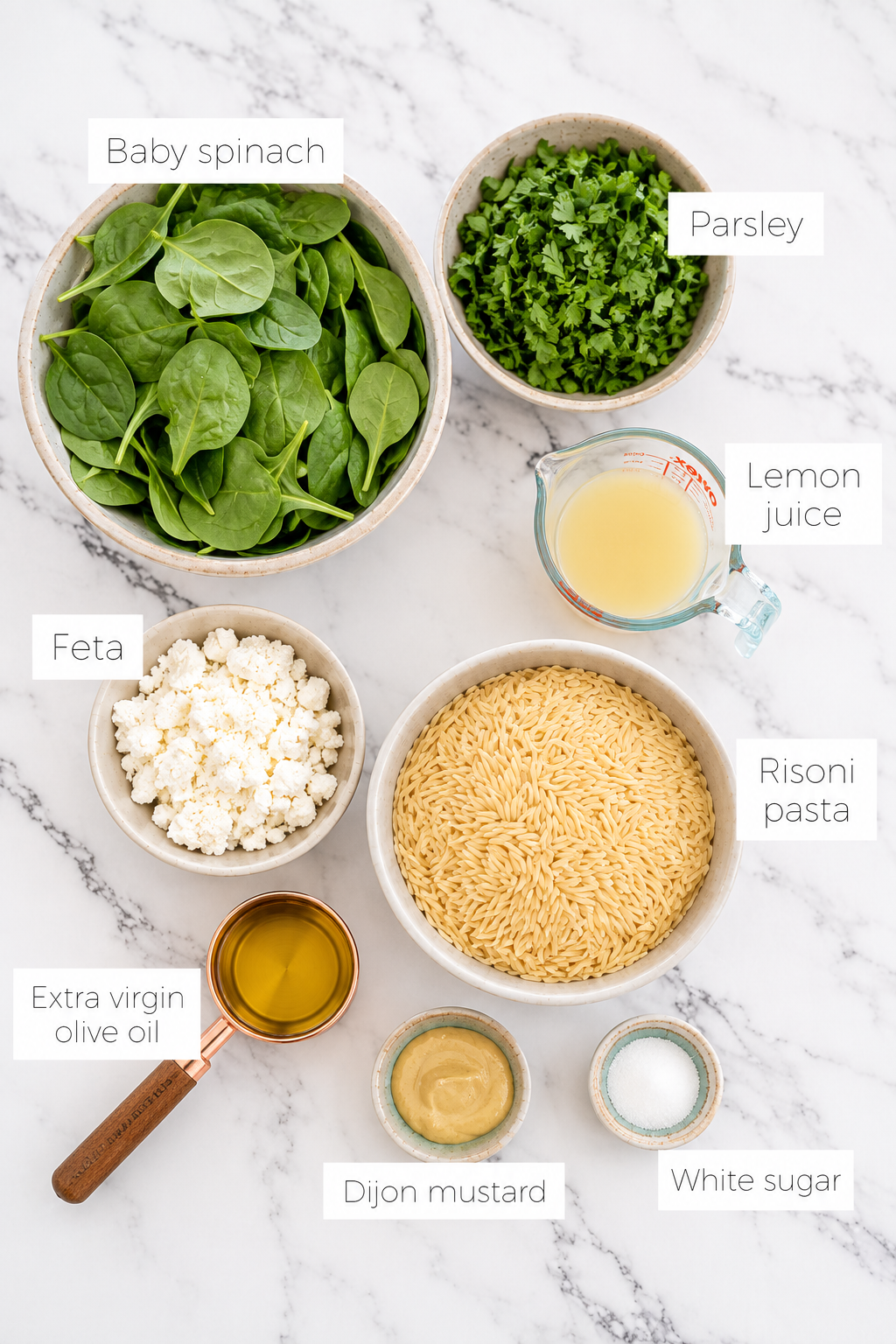 Ingredients for lemon risoni salad including risoni, spinach, feta, parsley, lemon juice and olive oil.