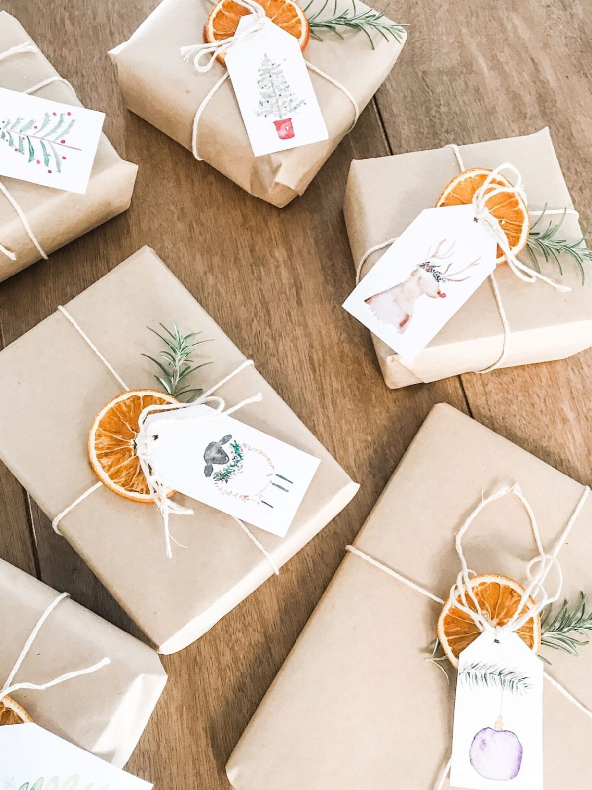 Presents wrapped in brown paper and string with dehydrated oranges and watercolour gift tags. 