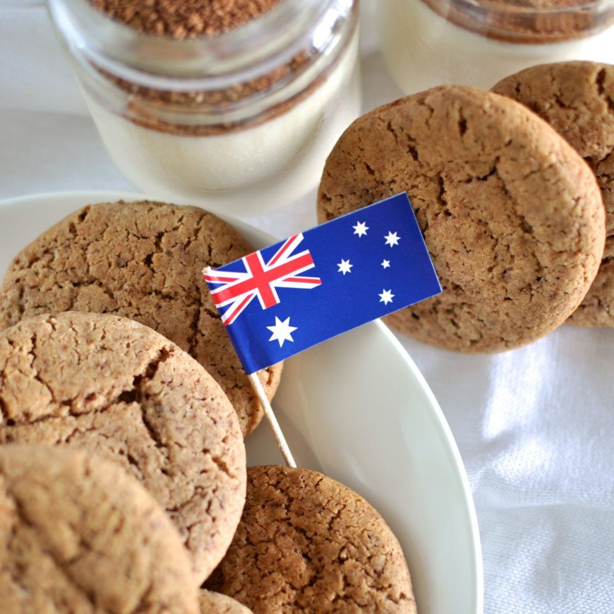 Milo Biscuits on a plate with a mini Australian flag and a glass of Milo and milk in the background.