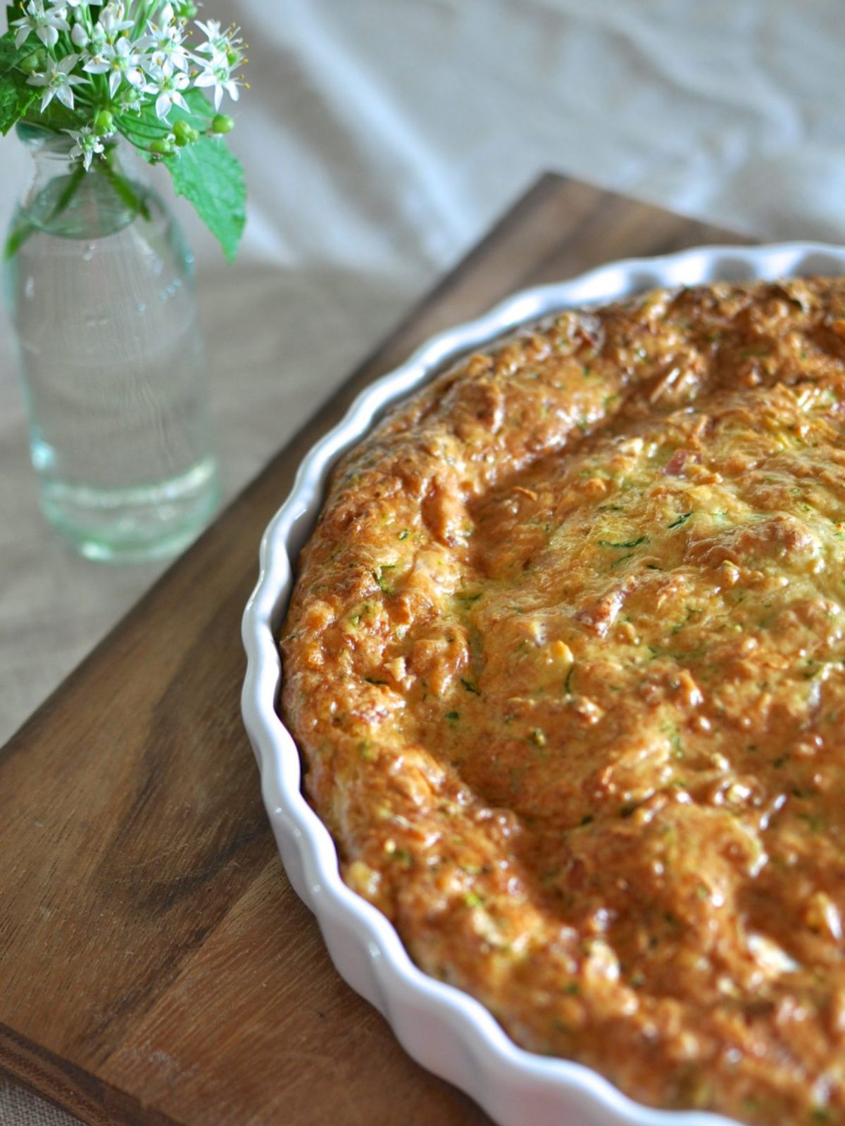 Zucchini And Bacon Slice in white ceramic quiche dish.