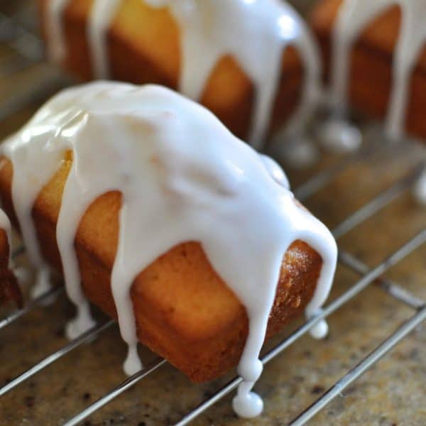 Mini lemon madeira loaf cake iced with white icing on a cooling rack
