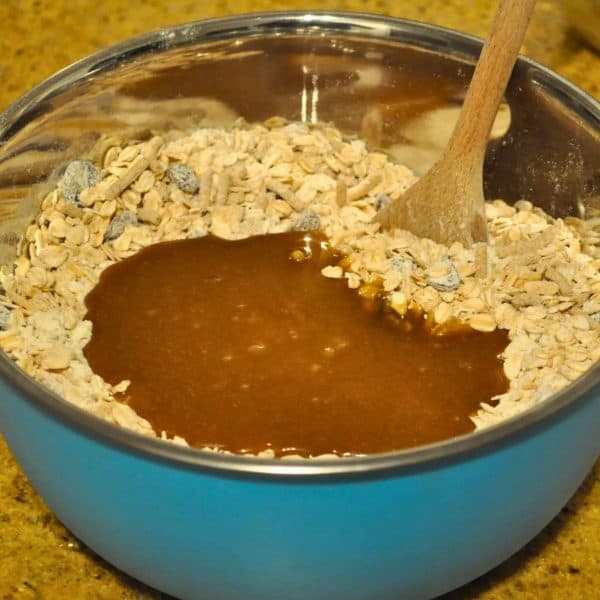 Mixing in the melted butter, sugar and honey to muesli bar mixture