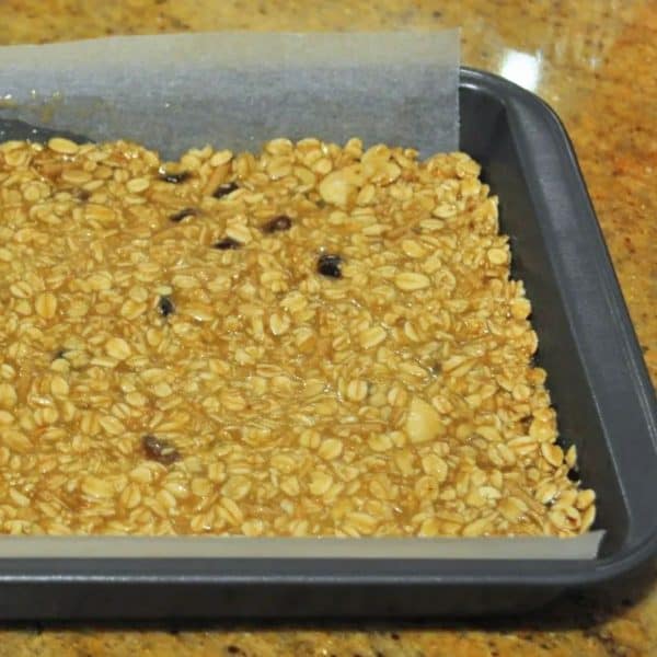 Spreading the muesli bar mixture in to a slice tin