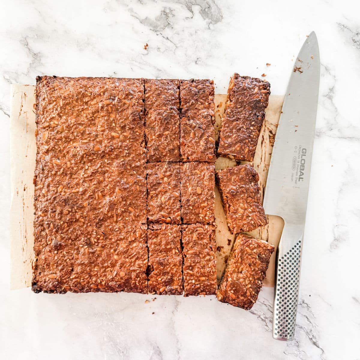 Slicing baked muesli bars into bars. 