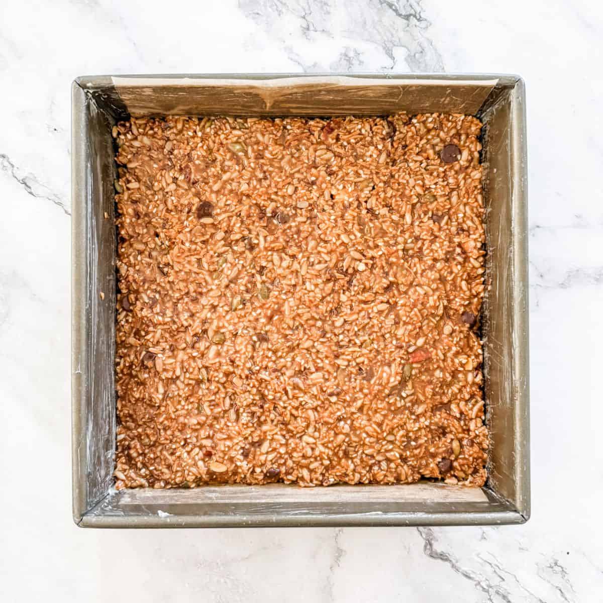 Muesli bar mixture spread into a square tin. 