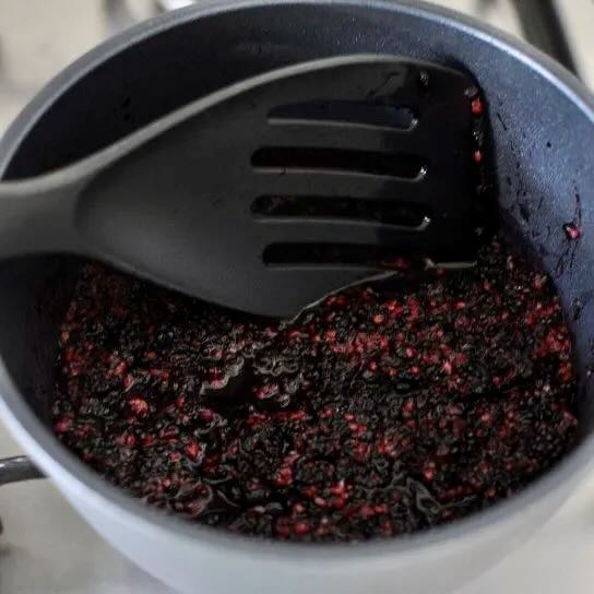 Fresh mulberries being cooked in a saucepan
