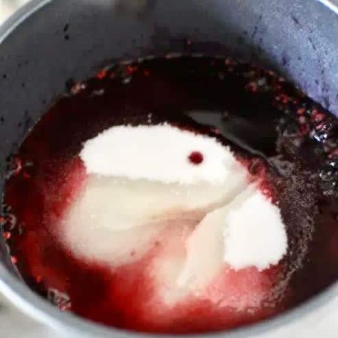 Sugar and lemon juice and mulberries in a saucepan
