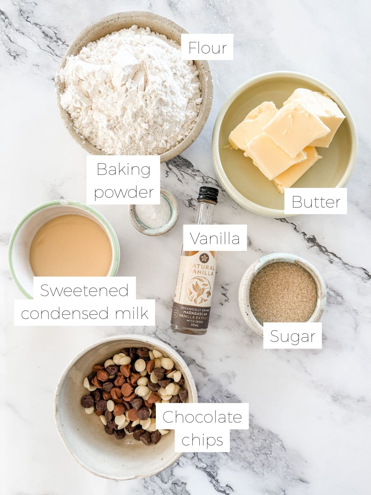 Ingredients for Sante biscuits. Bowl of flour, butter, sweetened condensed milk, vanilla, sugar, chocolate chips.