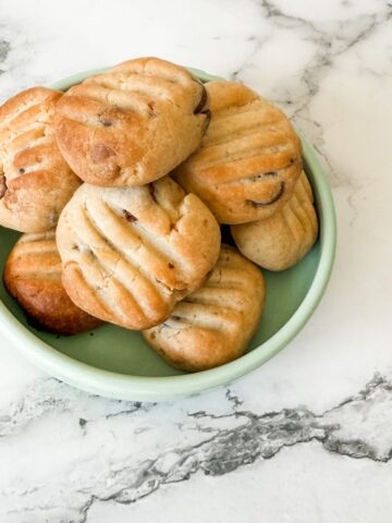 Bowl of chocolate chip Sante biscuits on a white marble bench top.