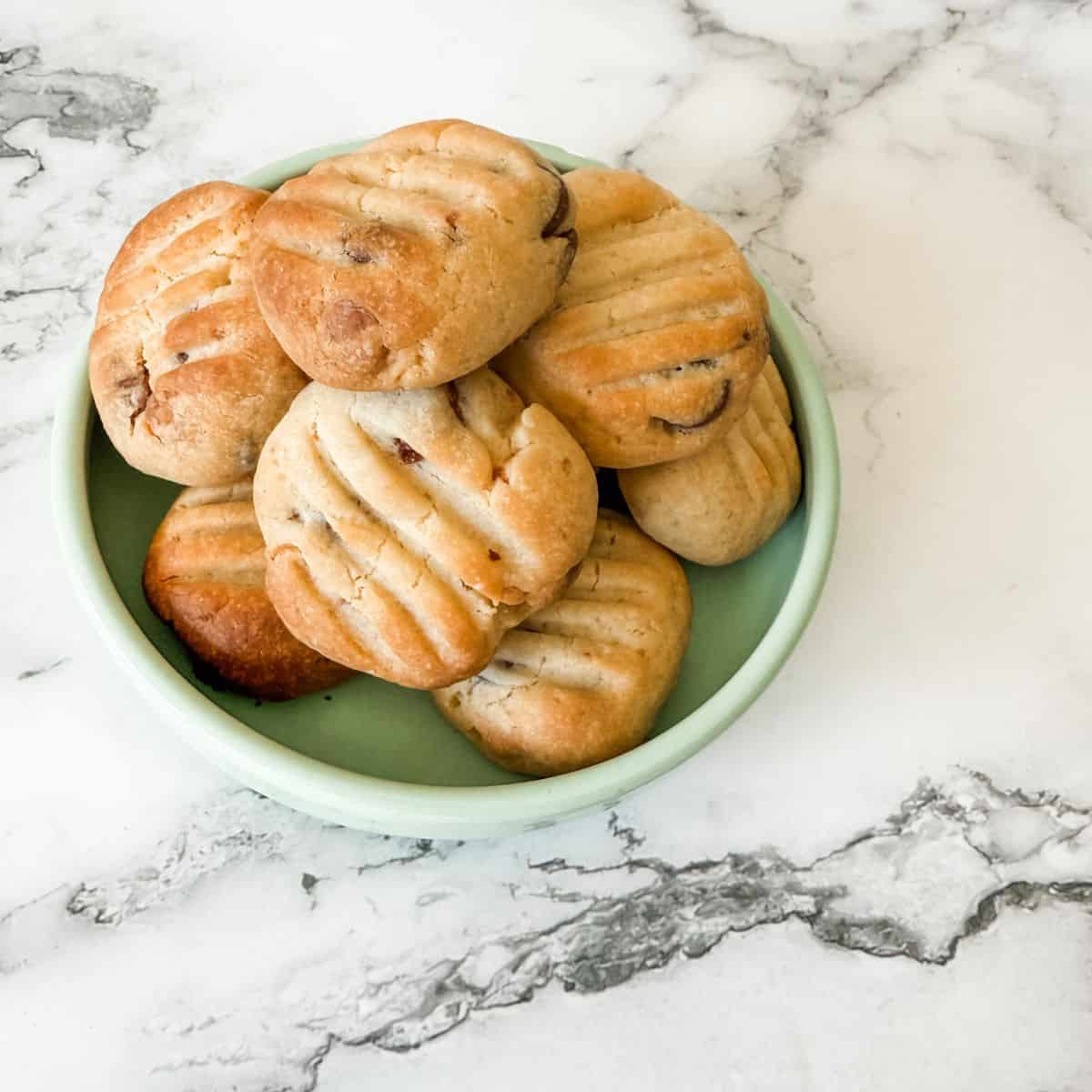 Bowl of chocolate chip Sante biscuits on a white marble bench top.