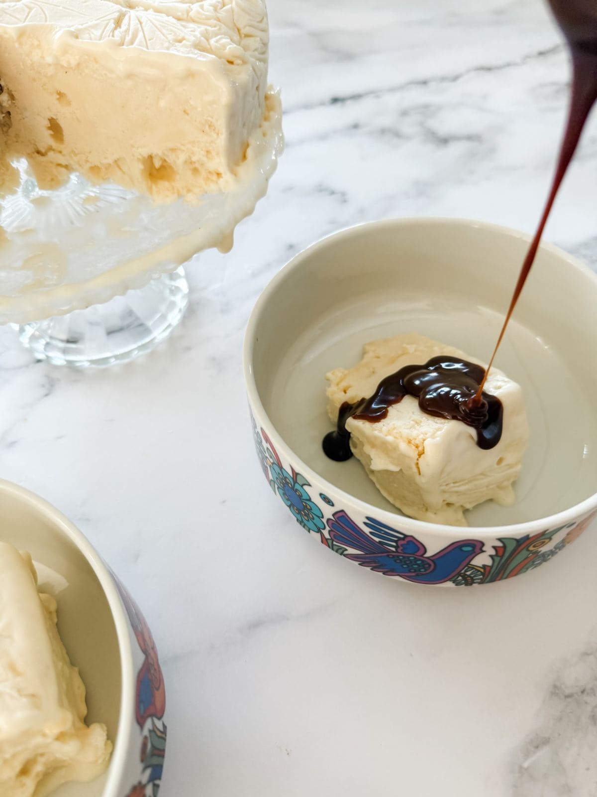 Lemon meringue ice cream served in bowls with chocolate sauce