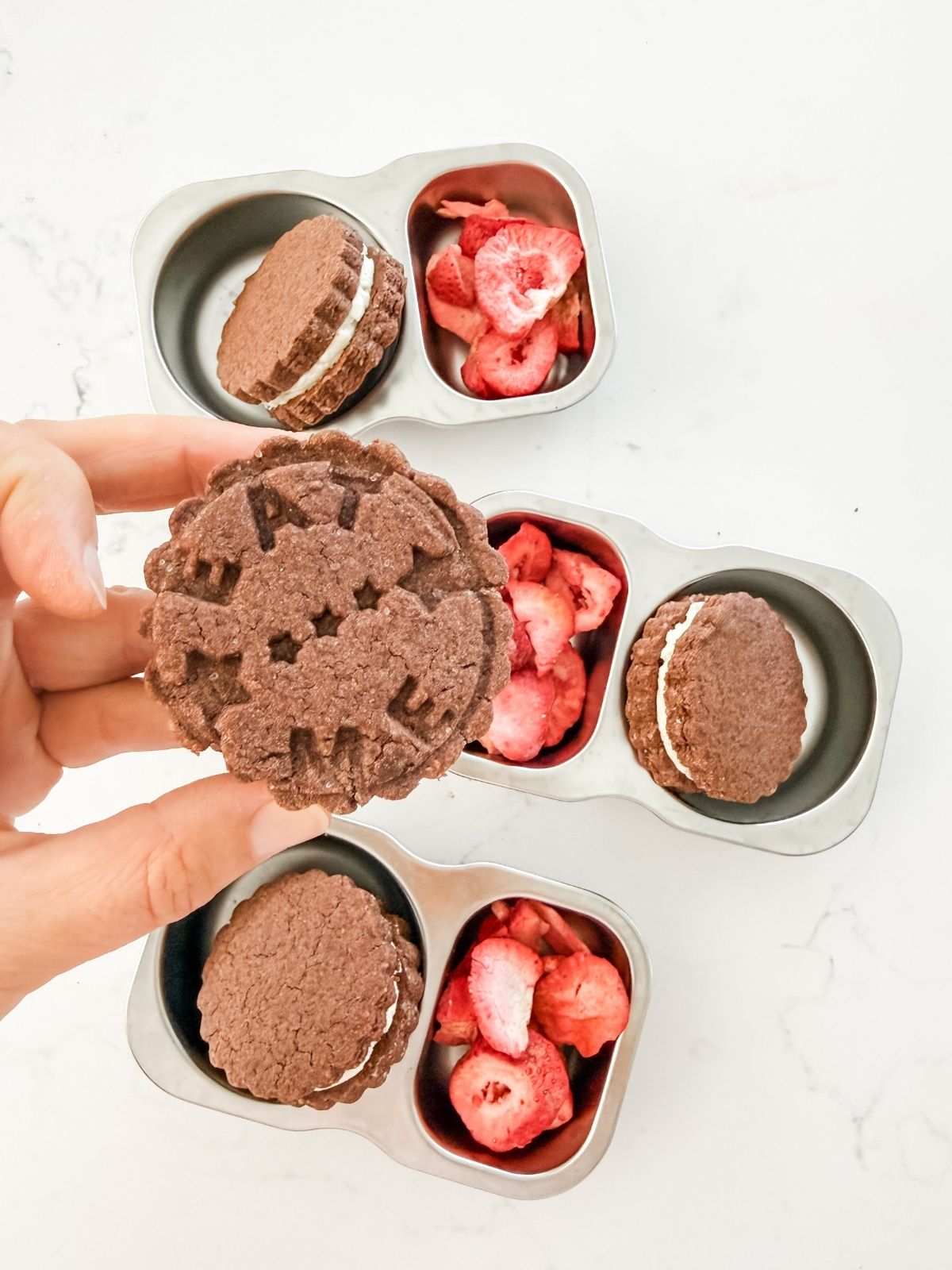 Chocolate sandwich cookie with eat me imprinted on it.